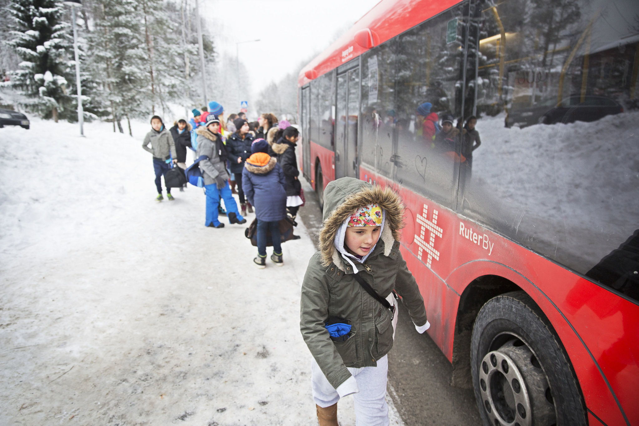 Skolebarn på siden av en buss